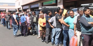 Ciudadanos hacen largas filas para recoger pasaporte