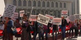 Un grupo de mujeres, con carteles, que visibilizan la violencia sexual contra la mujer, pasa enfrente del Palacio de Justicia
