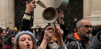 Gente golpea cazos en gesto de protesta durante un mensaje al nación del presidente, Emmanuel Macron,, ante el aumento de edad de la jubilización el lunes 17 de abril de 2023 en París.