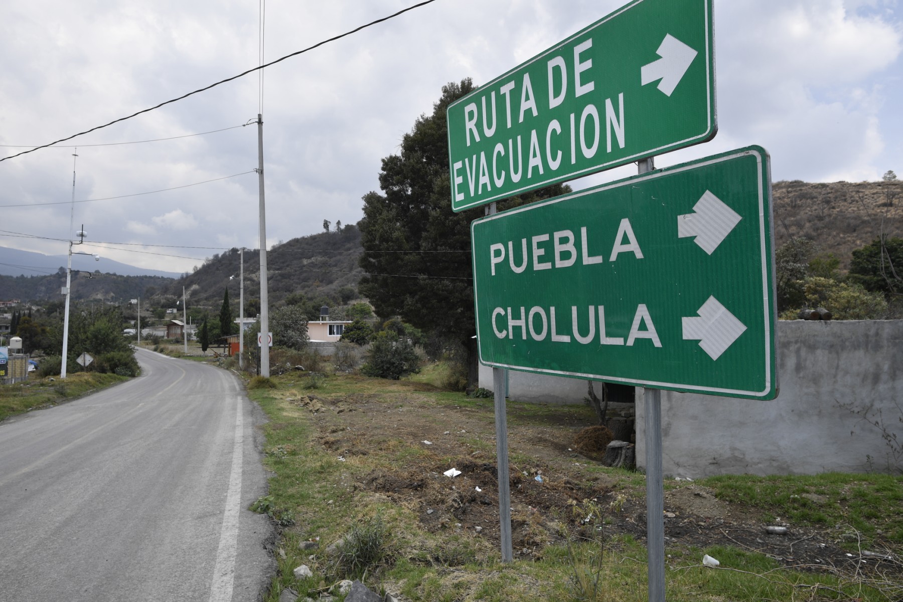 An evacuation route sign is seen in Santiago Xalitzintla, Puebla state, Mexico, on May 25, 2023. - The Popocatepetl volcano, located around 70 kilometres (about 45 miles) from Mexico City, spewed more gas and ash into the sky on May 23 as authorities maintained their warning level at one step below red alert. The government is monitoring Popocatepetl "day and night," President Andres Manuel Lopez Obrador said after the volcano put on another fiery show overnight. 