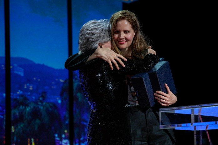 La directora de cine Justine Triet (derecha) abraza a Jane Fonda al aceptar la Palma de Oro por la cinta 