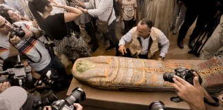 Mostafa Waziri, secretario general del Consejo Supremo de Antigüedades de Egipto, muestra un sarcófago antiguo de madera en el sitio de la pirámide escalonada de Zoser, en Saqqra, a unos 24 kilómetros (15 millas) al suroeste de El Cairo, Egipto, el sábado 27 de mayo de 2023