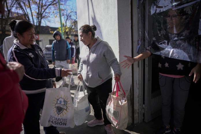 Las mujeres llevan bolsas de comida entregadas