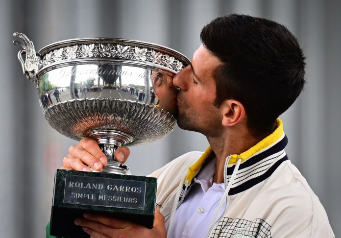 El serbio Novak Djokovic besa el Trofeo de los Mosqueteros durante una sesión de fotos después de ganar el torneo de tenis Roland-Garros French Open, en París, el 12 de junio de 2023.