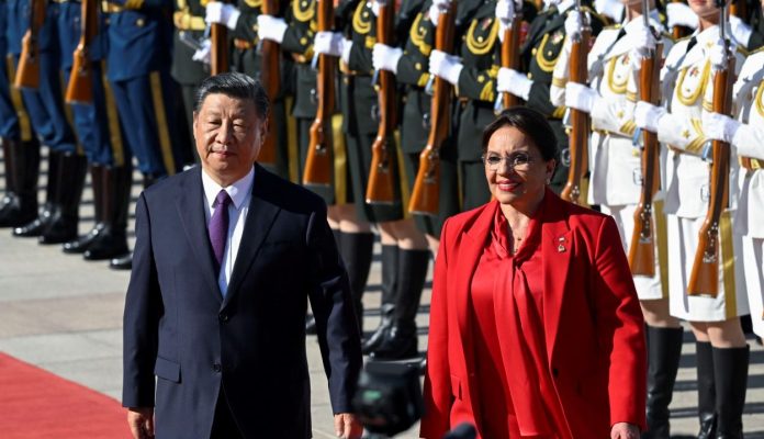 La presidenta de Honduras, Xiomara Castro (derecha), y el presidente de China, Xi Jinping (izquierda), inspeccionan a los guardias de honor chinos durante una ceremonia de bienvenida frente al Gran Salón del Pueblo en Beijing el 12 de junio de 2023.