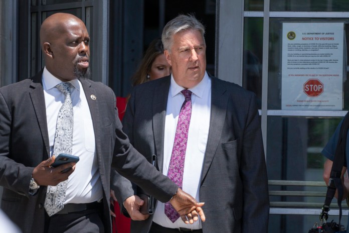 El abogado del expresidente Donald Trump, James Trusty (derecha), sale del edificio del Departamento de Justicia