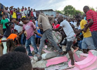 Varias personas ayudan a una persona herida después de que una casa se derrumbó debido a un sismo en Jeremie,