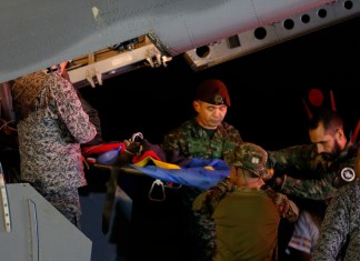 Personal militar baja en camilla a uno de los cuatro hermanos indígenas que pasaron 40 días desaparecidos en la selva tras un accidente de avión, en una base aérea del Ejército en Bogotá, Colombia.