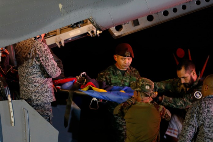 Personal militar baja en camilla a uno de los cuatro hermanos indígenas que pasaron 40 días desaparecidos en la selva tras un accidente de avión, en una base aérea del Ejército en Bogotá, Colombia.