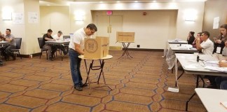 Imagen de una persona simulando el ejercicio del voto, en un simulacro de elecciones en el extranjero, TSE.