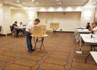 Imagen de una persona simulando el ejercicio del voto, en un simulacro de elecciones en el extranjero, TSE.