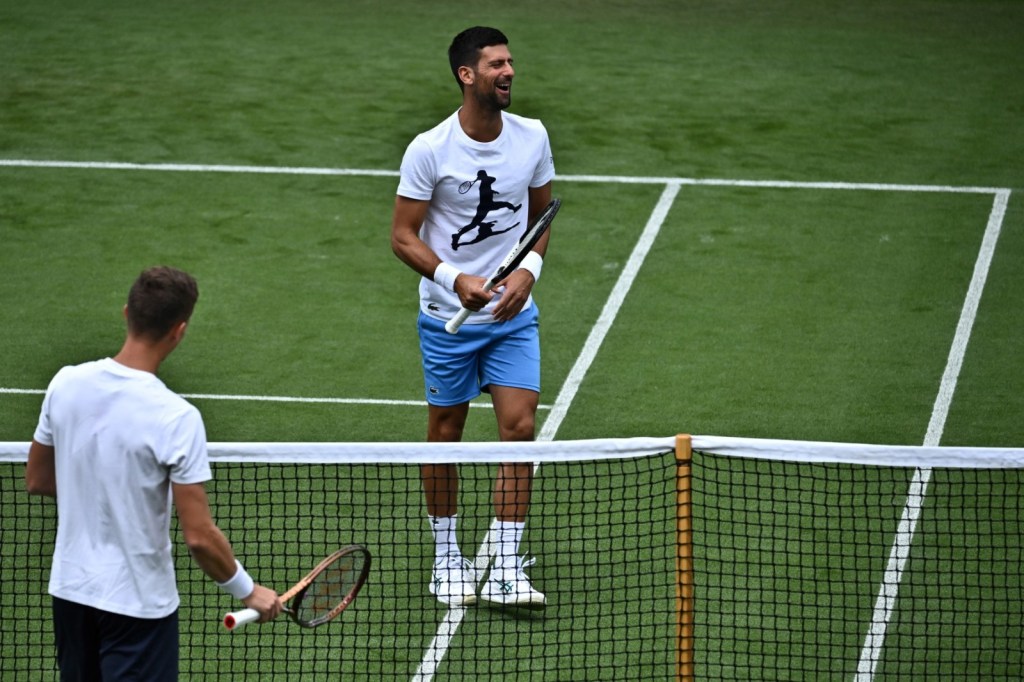 El serbio Novak Djokovic reacciona mientras participa en una sesión de entrenamiento en el All England Lawn Tennis Club. Foto La Hora/AFP