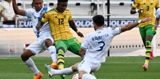 El delantero de Jamaica Demarai Gray (C) compite por el balón con el defensor de Guatemala José Ardón (L) y el defensor de Guatemala José Pinto (D) durante el partido de fútbol de cuartos de final de la Copa Oro