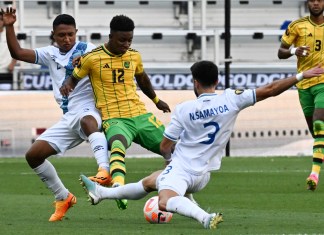 El delantero de Jamaica Demarai Gray (C) compite por el balón con el defensor de Guatemala José Ardón (L) y el defensor de Guatemala José Pinto (D) durante el partido de fútbol de cuartos de final de la Copa Oro