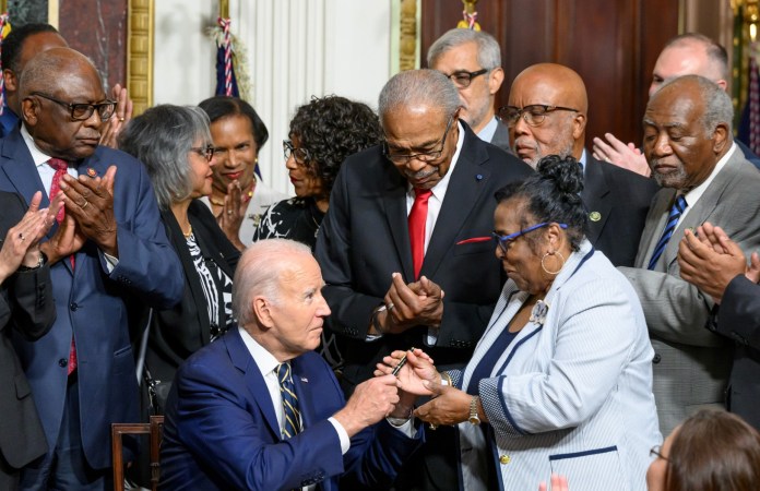 El presidente de EE. UU., Joe Biden, entrega un bolígrafo al miembro de la familia Till, después de firmar una proclamación que establece el Monumento Nacional Emmett en Illinois y Mississippi, cerca de la Casa Blanca, en Washington.