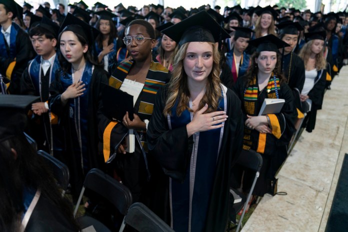Estudiantes entonan el himno nacional de Estados Unidos durante una ceremonia de graduación de la generación Georgetown de 2022 en la Walsh School of Foreign Service.