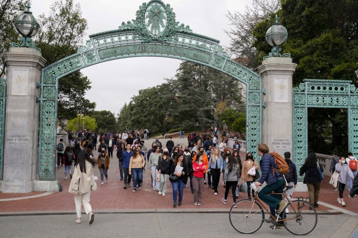 Un grupo de estudiantes pasa por la Puerta Sather cerca de la Plaza Sproul en la Universidad de California, campus de Berkeley, el martes 29 de marzo de 2022, en Berkeley, California.