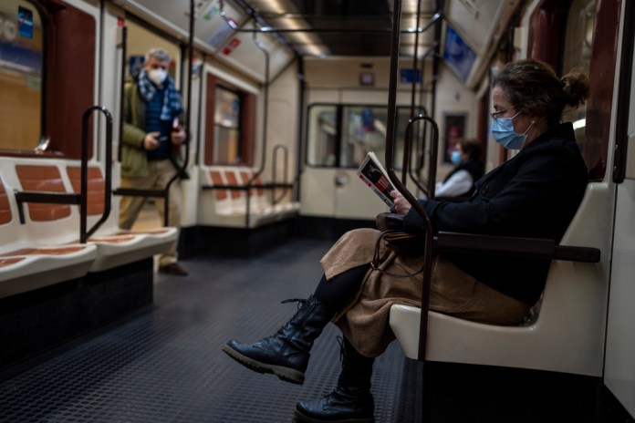 Una mujer con mascarilla viaja en el metro de Madrid, 20 de enero de 2022. El gobierno declaró el martes 4 de julio de 2023 el fin de la crisis sanitaria provocada por el COVID-19.