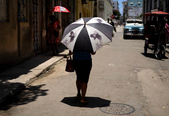 Una persona se protege del calor bajo una sombrilla en una calle de La Habana, Cuba, el 5 de julio de 2023.