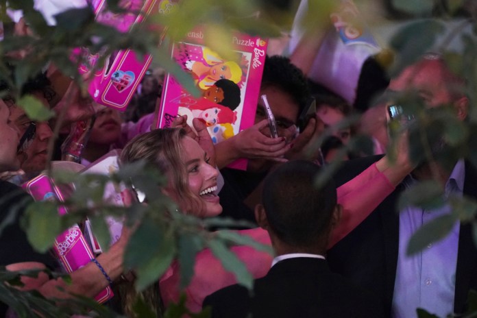 La actriz Margot Robbie se toma fotos con los fans en la alfombra rosa de la película "Barbie"