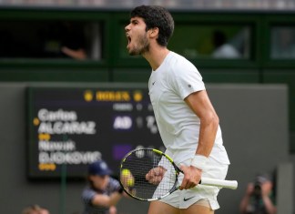 Carlos Alcaraz grita tras ganar un punto ante Novak Djokovic durante la final masculina de Wimbledon en Londres.