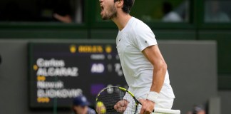 Carlos Alcaraz grita tras ganar un punto ante Novak Djokovic durante la final masculina de Wimbledon en Londres.