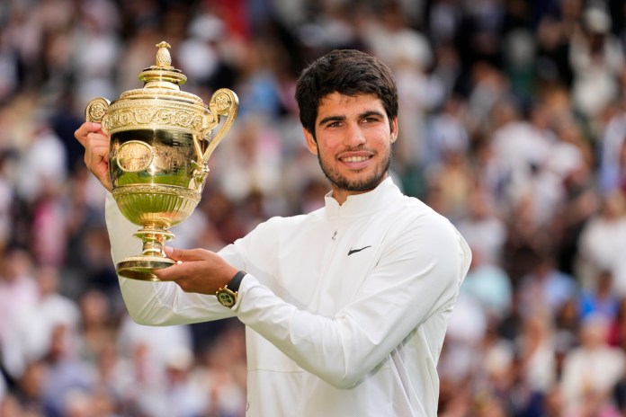 Carlos Alcaraz alza el trofeo de campeón de Wimbledon tras derrotar a Novak Djokovic.