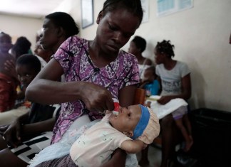 Cetout Widlore alimenta a su hija Naomie Cesar, de siete meses, luego que personal de salud revisara el estado de salud de la bebé en el Centro Gheskio, en Puerto Príncipe, Haití.
