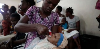 Cetout Widlore alimenta a su hija Naomie Cesar, de siete meses, luego que personal de salud revisara el estado de salud de la bebé en el Centro Gheskio, en Puerto Príncipe, Haití.