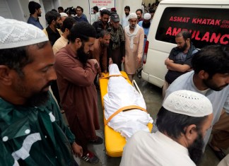 Familiares trasladan el cuerpo de un hombre fallecido tras el derrumbe de un muro debido a las lluvias del monzón en el hospital PIMS, en Islamabad, Pakistán.