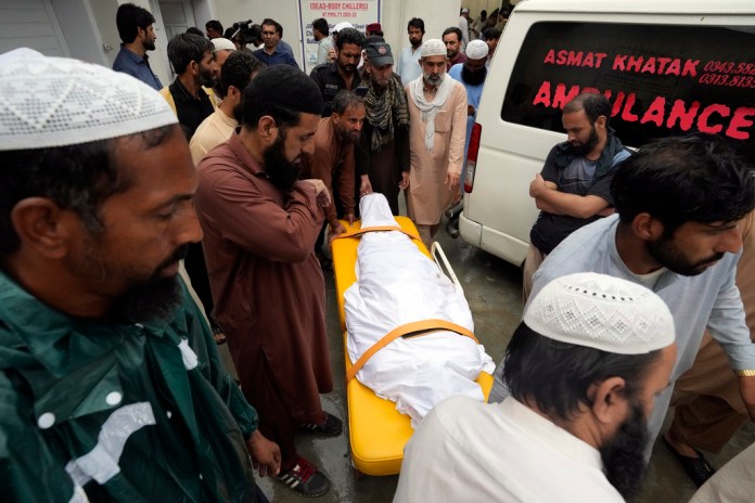 Familiares trasladan el cuerpo de un hombre fallecido tras el derrumbe de un muro debido a las lluvias del monzón en el hospital PIMS, en Islamabad, Pakistán.