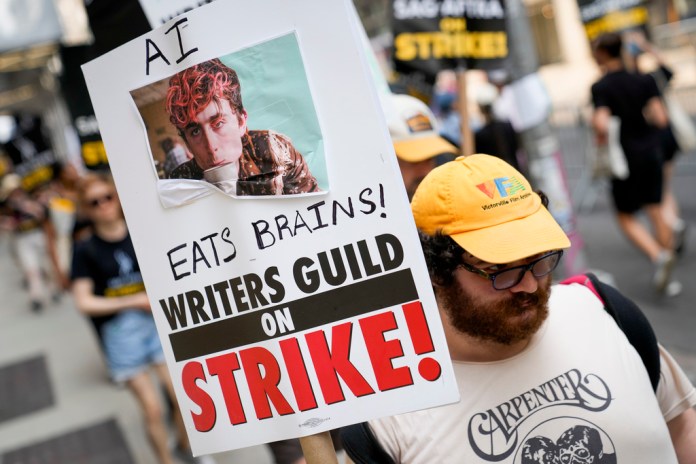 Un cartel de burla sobre la inteligencia artificial en un mitin de guionistas y actores en huelga. 