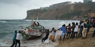 Un grupo de personas ayuda para sacar del mar un bote que, de acuerdo con testigos, naufragó en las costas de Dakar, Senegal, el lunes 24 de julio de 2023.