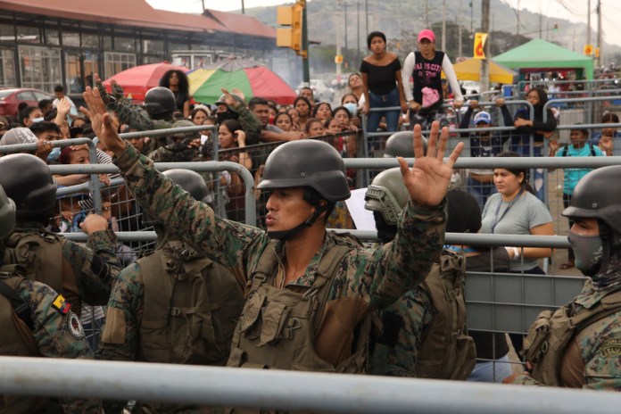Un militar pide calma a los amigos y familiares de presos que buscaban información sobre sus seres queridos tras los enfrentamientos con muertos en la Penitenciaría del Litoral de Guayaquil, Ecuador, 