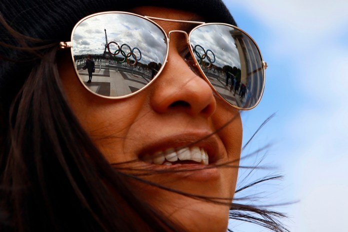  Los anillos olímpicos se reflejan en unos lentes de sol en la plaza Trocadero, cerca de la torre Eiffel.