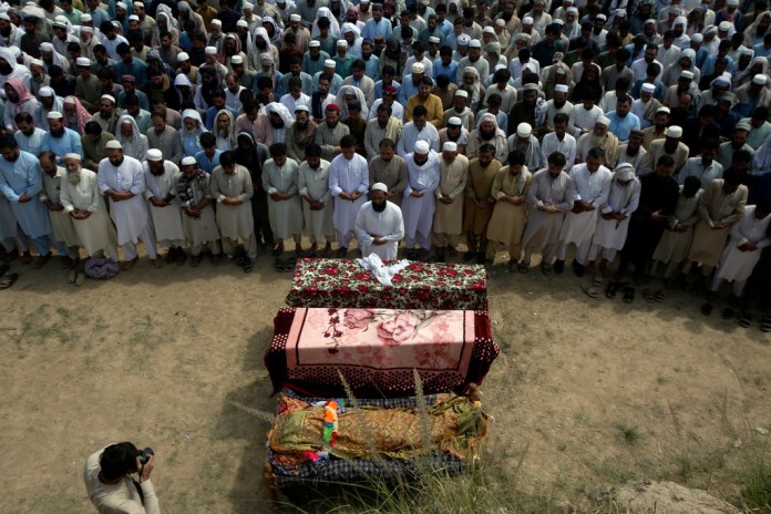 Familiares y otros dolientes oran en el funeral de víctimas de un atentado suicida en un mitin electoral ocurrido en la víspera, en la provincia de Khyber Pakhtunkhwa, Pakistán, el lunes 31 de julio de 2023.