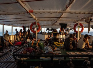 La imagen tomada el 5 de agosto de 2023 muestra a algunos migrantes rescatados, de un grupo de 266, descansando a bordo del barco de la ONG española Proactiva Open Arms frente a las costas de Libia, dos días después de su rescate cuando intentaban cruzar el mar Mediterráneo en pequeños botes.
