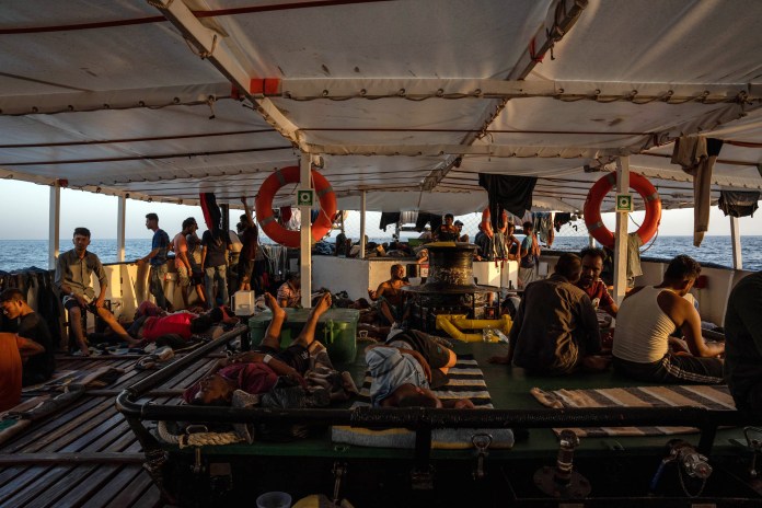 La imagen tomada el 5 de agosto de 2023 muestra a algunos migrantes rescatados, de un grupo de 266, descansando a bordo del barco de la ONG española Proactiva Open Arms frente a las costas de Libia, dos días después de su rescate cuando intentaban cruzar el mar Mediterráneo en pequeños botes.