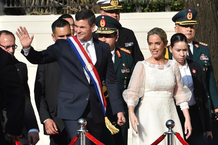 El nuevo presidente de Paraguay, Santiago Peña (izquierda), y su esposa, la primera dama, Leticia Ocampos, asisten a un desfile militar y policial en honor a los presidentes presentes en su toma de posesión.
