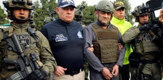 La policía escolta a Dairo Antonio Úsuga (al frente segundo de la derecha), líder del Clan del Golfo, para extraditarlo a Estados Unidos, en un aeropuerto militar en Bogotá.