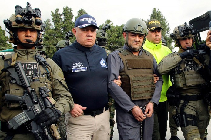 La policía escolta a Dairo Antonio Úsuga (al frente segundo de la derecha), líder del Clan del Golfo, para extraditarlo a Estados Unidos, en un aeropuerto militar en Bogotá.