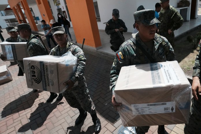 Soldados entregan materiales electorales en un centro de votación en Quito,