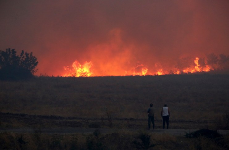 Gente observa un incendio forestal cerca de la ciudad nororiental de Alejandrópolis, Grecia, el domingo 20 de agosto de 2023.