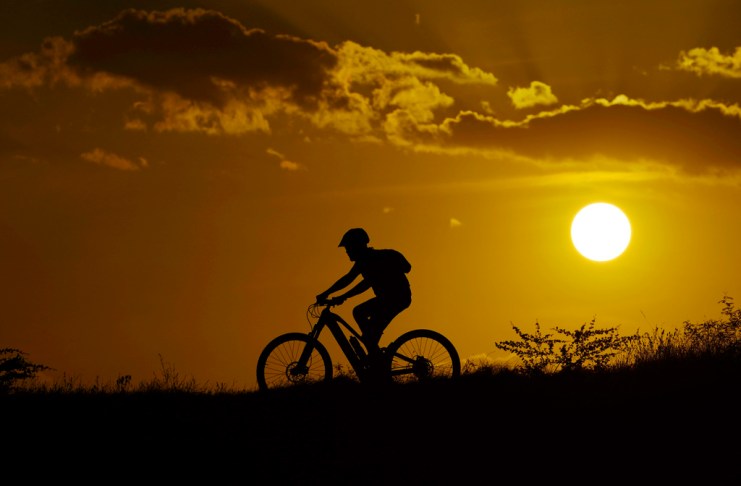 Un ciclista cruza lo alto de una colina durante la puesta del sol en San Antonio, Texas, pese a la advertencia de ola de calor. Foto La Hora: AP