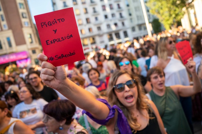 Una manifestante, con una tarjeta roja en la que dice "Piquito y dimisión", participa en una protesta contra el presidente de la Federación Española de Fútbol, Luis Rubiales, y en apoyo de la futbolista de la selección femenina Jenni Hermoso, en Madrid, el 28 de agosto de 2023.