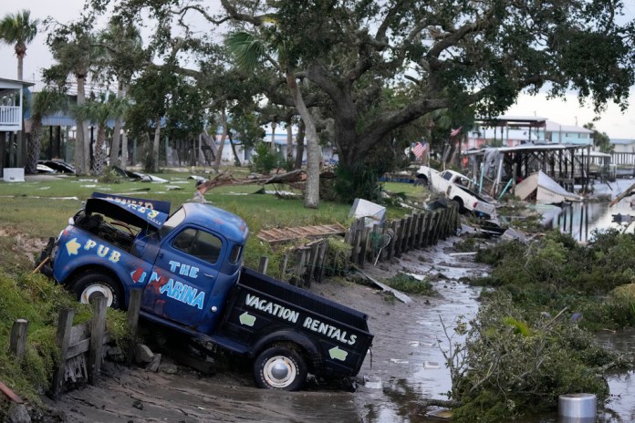 Camionetas y escombros obstruyen el flujo de las aguas de un canal en Horseshoe Beach, Florida, tras el paso de Idalia.