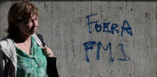 Una mujer pasa junto a un graffiti que dice "Fuera FMI" en español en Buenos Aires el 14 de agosto de 2023, un día después de las elecciones primarias.