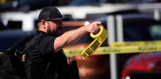 Imagen ilustrativa de un agente de la ley lleva un rollo de cinta de la escena del crimen después de que un hombre armado abriera fuego en el edificio del Old National Bank el 10 de abril de 2023.