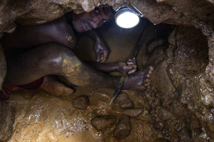 Un minero venezolano trabaja con una barra para excavar y extraer oro