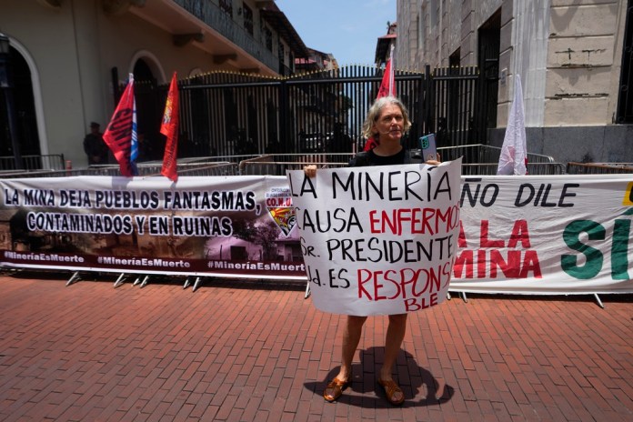 Una mujer sostiene un cartel con un mensaje que dice en español 